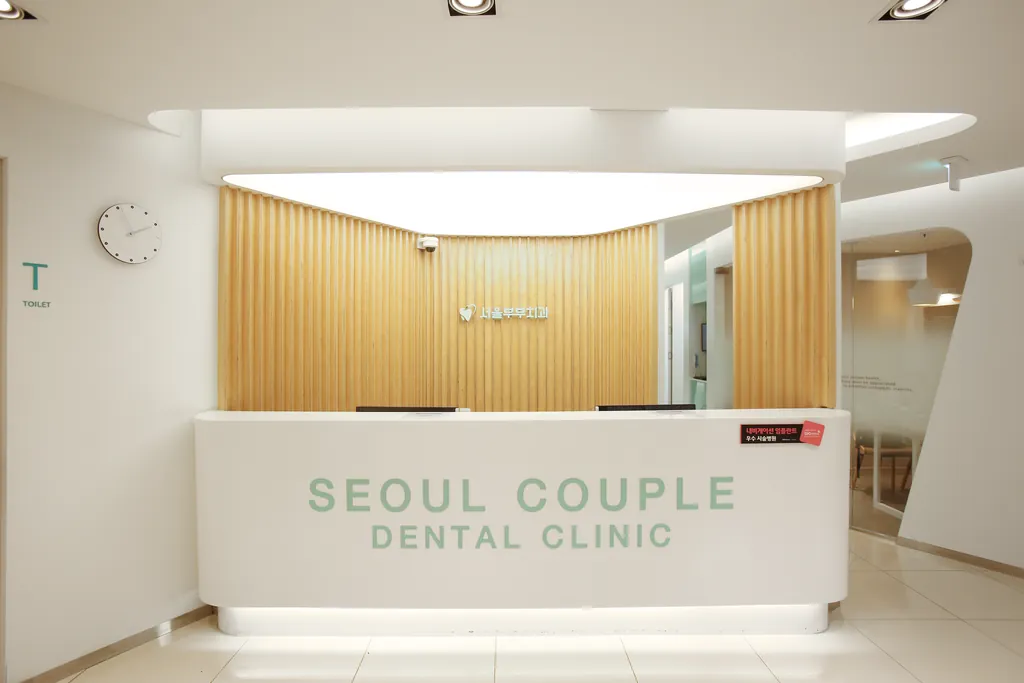 원목 루버 벽 앞의 안내데스크